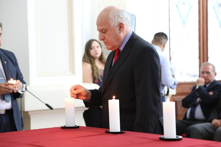 El gobernador encendiendo una de las seis velas que representan cada millón de judíos víctimas del genocidio.