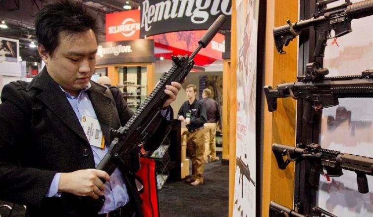 Kevin Kao examina un rifle de combate Remington en Las Vegas. AP