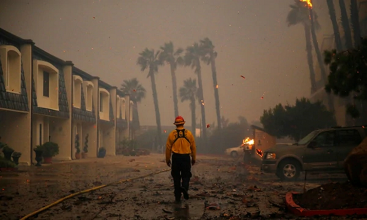 Un bombero camina por zona aledaña que aún no ha sido devastada por el incendio. (Reuters)