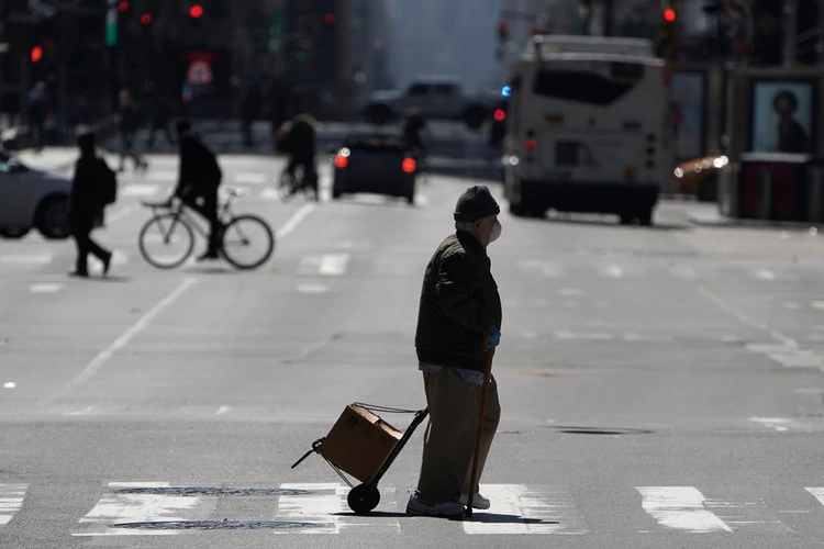 Un peatón camina con protección por las calles de Nueva York durante el brote de coronavirus en EEUU (REUTERS/Carlo Allegri)
