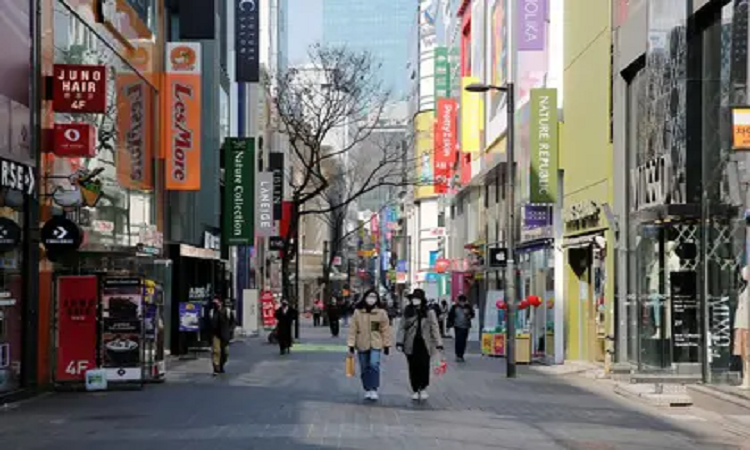 Mujeres con mascarillas de protección caminan por las calles de la capital surcoreana durante el brote del nuevo coronavirus en Seúl, Corea del Sur