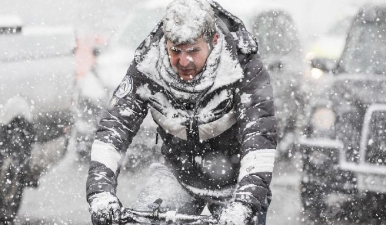 Un hombre circula cubierto de nieve en bicicleta haciéndole frente al invierno en Londres (Foto: DPA)