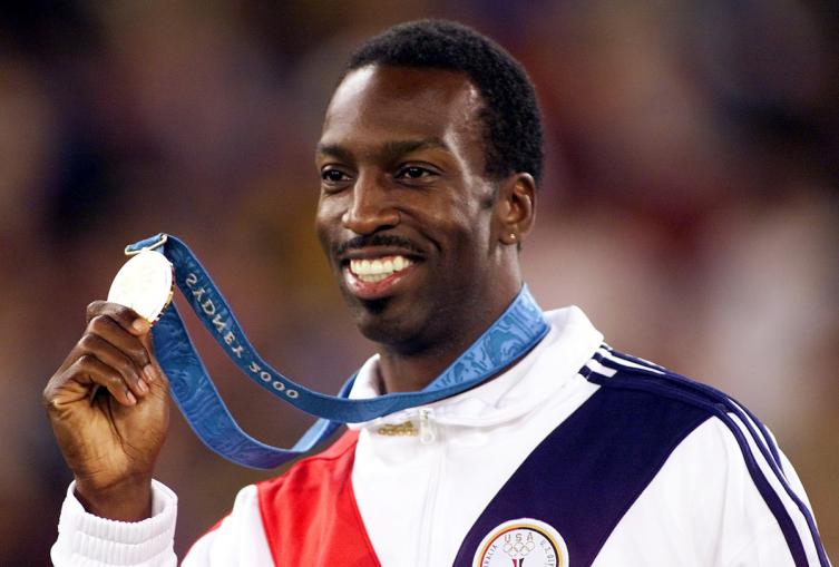 Michael Johnson muestra la medalla de oro que obtuvo en los 400 metros de los Juegos Olímpicos de Sydney 2000. (AP)
