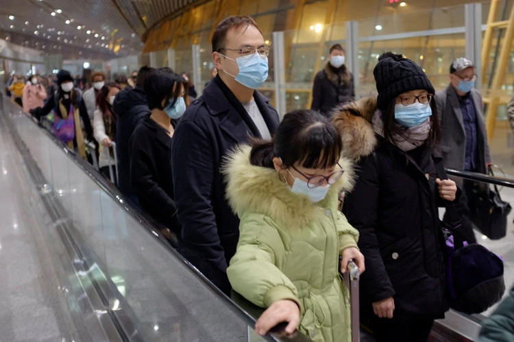 La gente usa máscaras de protección al llegar al Aeropuerto Internacional de Pekín el 25 de enero de 2020 (REUTERS/Thomas Peter)