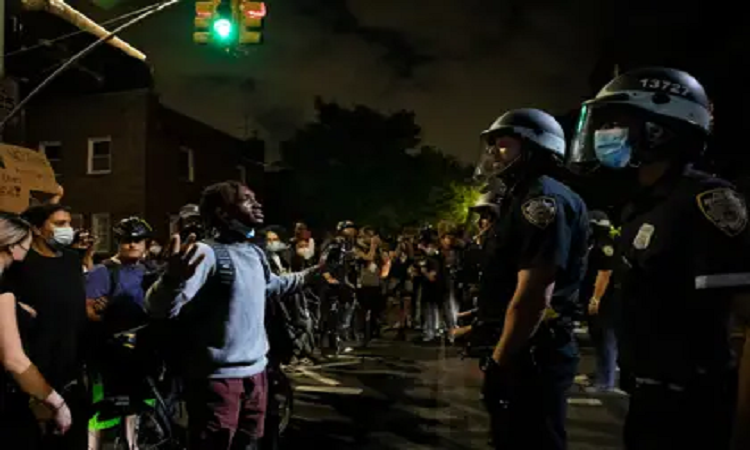 Un manifestante discute con un oficial de la policia en Nueva York - INFOBAE